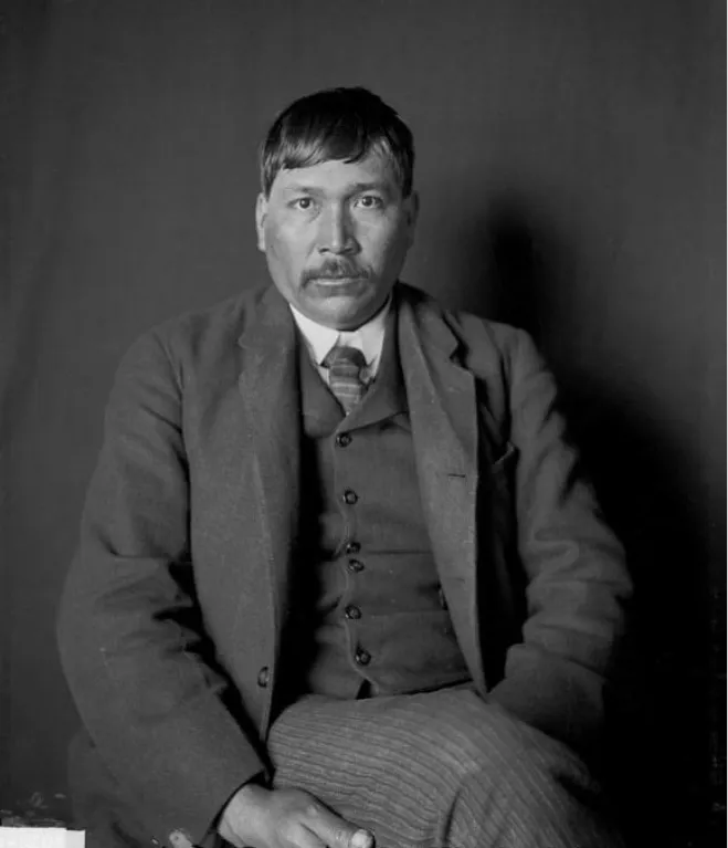 A black and white archival portrait of Chief David One Toad Harris wearing a formal vest and suit jacket.